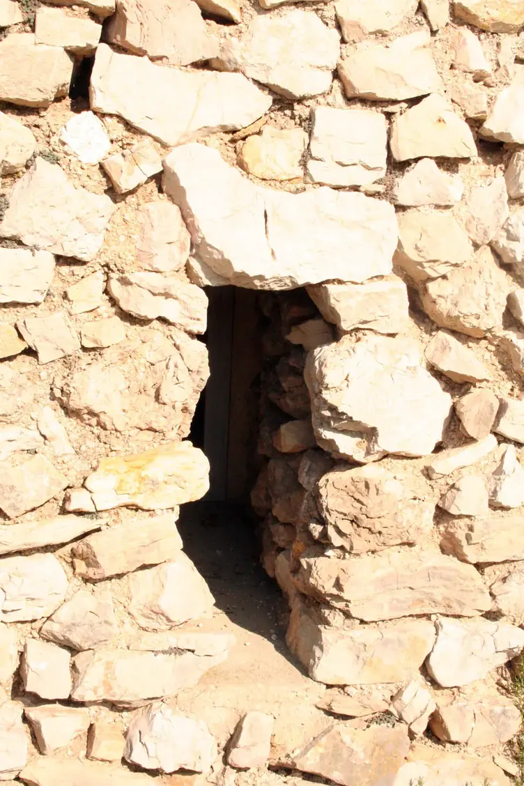 Meurtrière dans le mur de pierre sèche de la bergerie